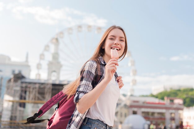 Primer plano de mujer sosteniendo helado de paleta y sonriendo