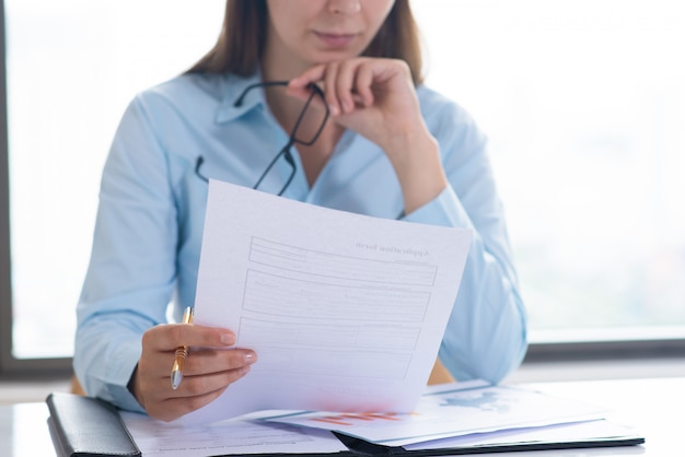 Primer plano de mujer sosteniendo y leyendo el documento