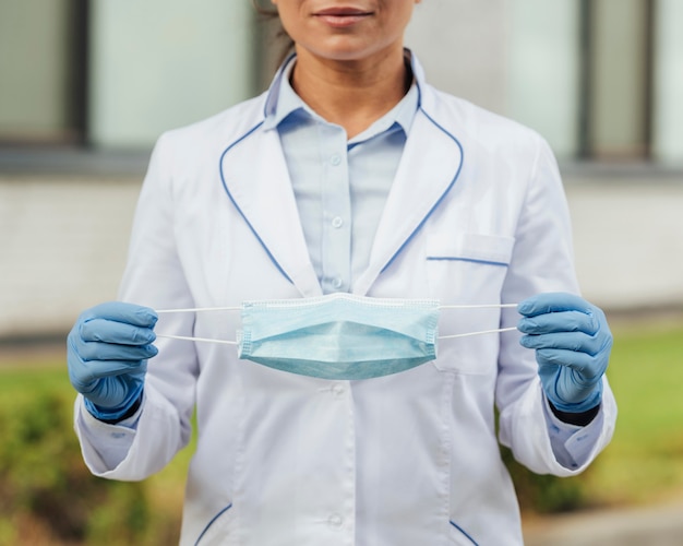 Foto gratuita primer plano mujer sosteniendo máscara médica