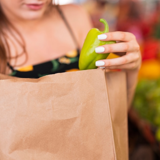 Primer plano mujer sosteniendo un pimiento