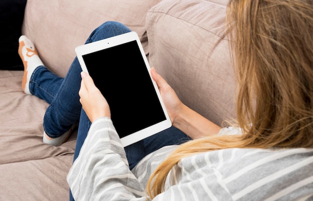 Primer plano de una mujer sosteniendo tableta digital con pantalla en blanco