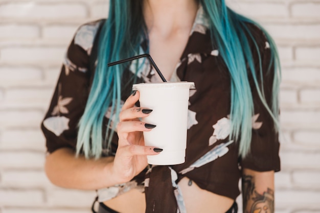 Primer plano de una mujer sosteniendo la taza de café para llevar