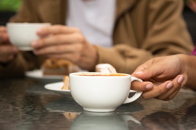 Primer plano de mujer sosteniendo la taza de café