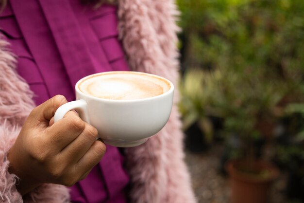 Primer plano de mujer sosteniendo una taza de café