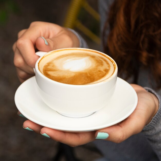 Primer plano de mujer sosteniendo la taza de café