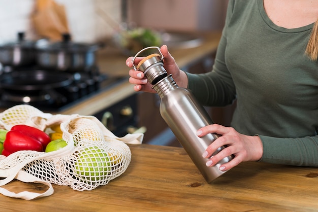 Primer plano mujer sosteniendo termo botella