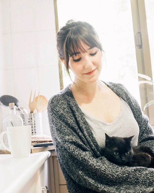 Foto gratuita primer plano de una mujer con su gatito en la cocina