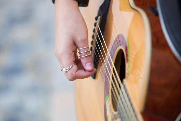 Primer plano de mujer tocando la guitarra acústica