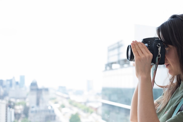 Primer plano de una mujer tomando fotos en la cámara réflex digital