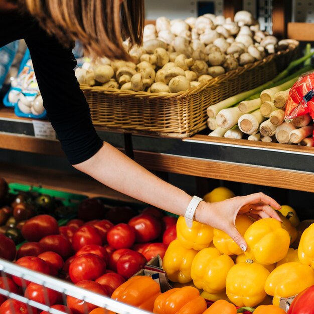 Primer plano mujer tomando un pimiento amarillo