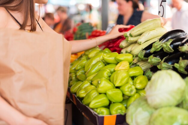 Primer plano mujer tomando un pimiento rojo