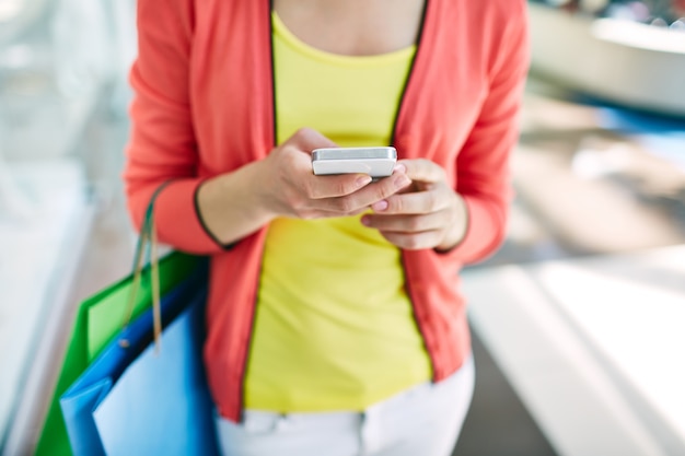 Primer plano de mujer usando su teléfono móvil