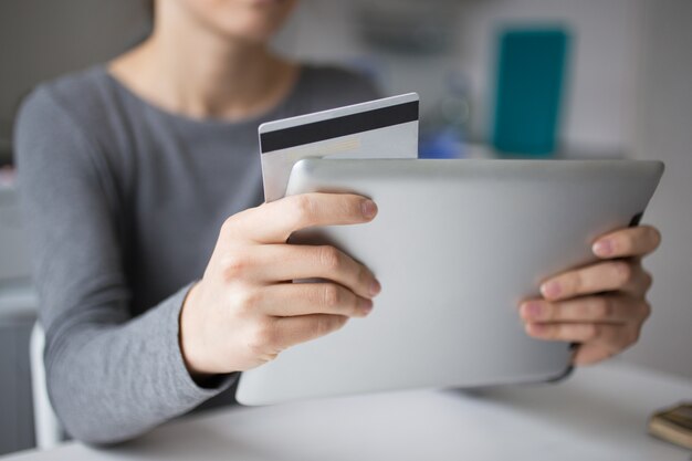 Primer plano de mujer usando tableta y tarjeta de crédito