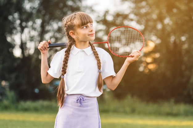 Foto gratuita primer plano de una niña con bádminton mirando a otro lado