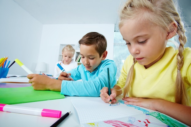 Primer plano de niña dibujando en el cuaderno