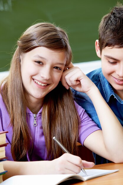 Primer plano de niña dibujando en su cuaderno con su novio