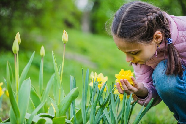 Primer plano de niña junto a una flor amarilla