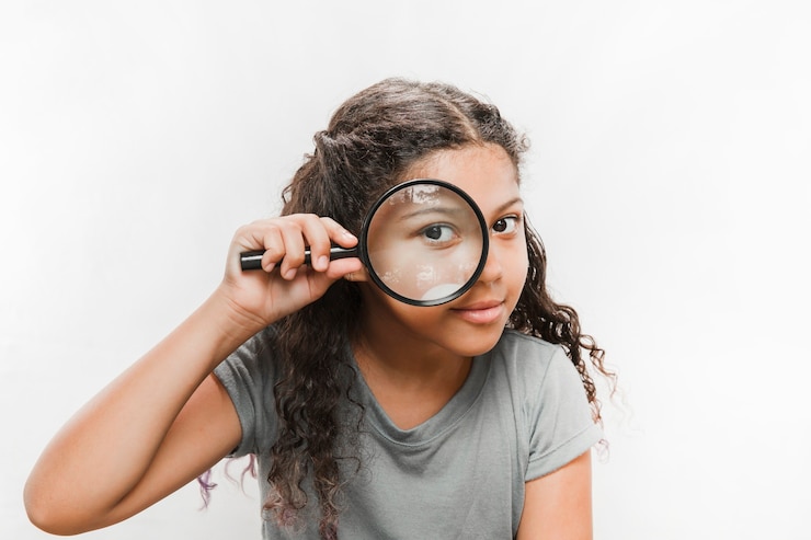 Foto gratuito primer plano de una niña mirando a través de la lupa