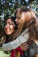 Foto gratuita primer plano de una niña pequeña detrás de su hermana mayor en un parque