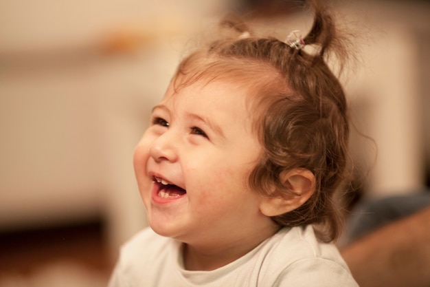 Primer plano de niña pequeña riéndose