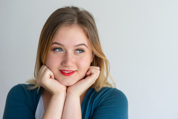 Primer plano de niña soñadora sonriente con labios rojos