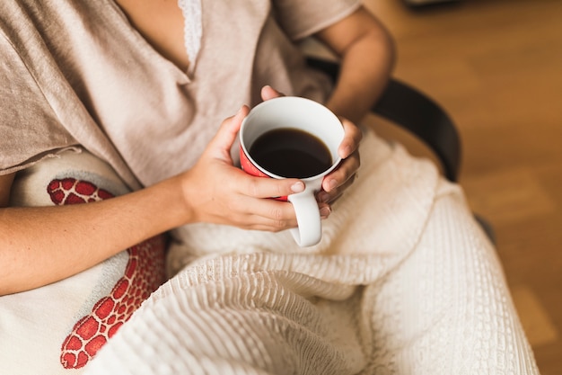 Foto gratuita primer plano de niña sosteniendo una taza de café en las manos