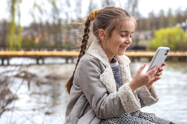 Primer plano, de, un, niña, con, un, teléfono, en, ella, manos