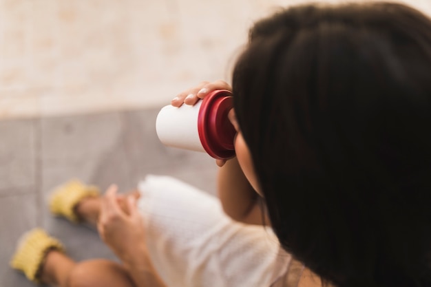 Primer plano de una niña tomando café para llevar