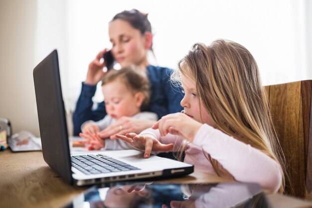 Primer plano, de, un, niña, usar la computadora portátil, encima, escritorio de madera