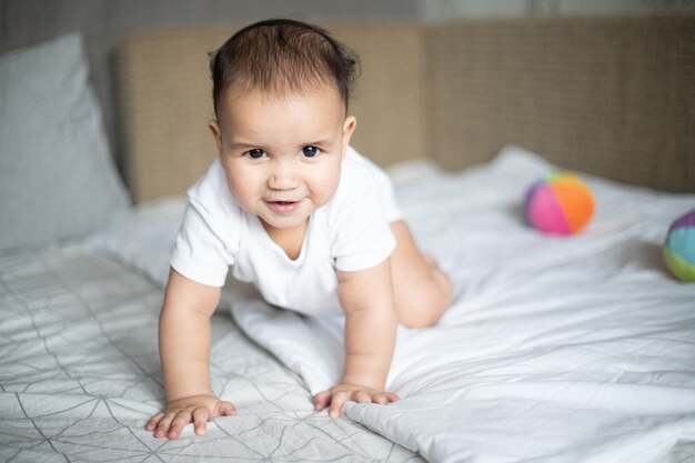 Primer plano de un niño alegre en la cama bajo las luces de una habitación