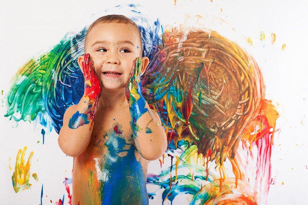 Primer plano de niño encantador lleno de pintura