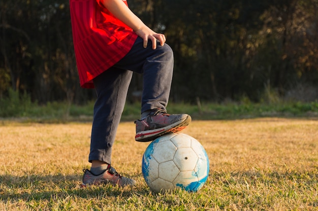 Foto gratuita primer plano de niño jugando con fútbol en el parque