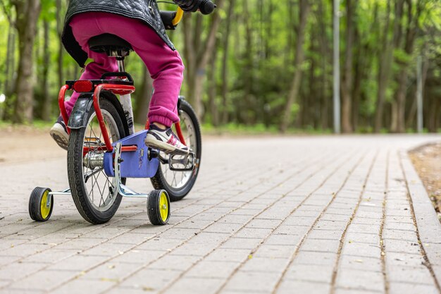 Primer plano, de, un, niño, monta una bicicleta, con, tres ruedas