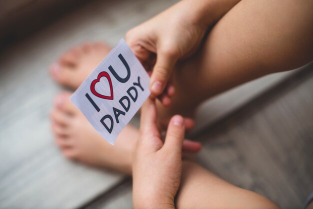 Primer plano de niño sujetando una nota para el día del padre