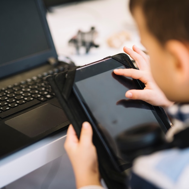 Primer plano de un niño tocando la pantalla de la tableta digital