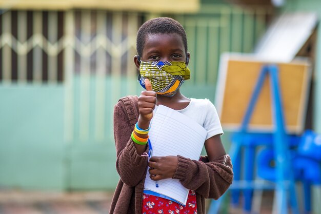 Primer plano de un niño varón negro sosteniendo un cuaderno