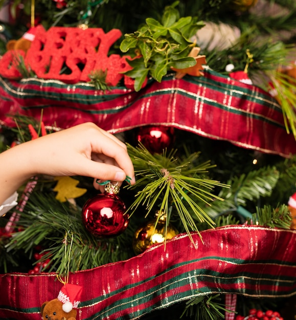 Primer plano de niños decorando un árbol en navidad