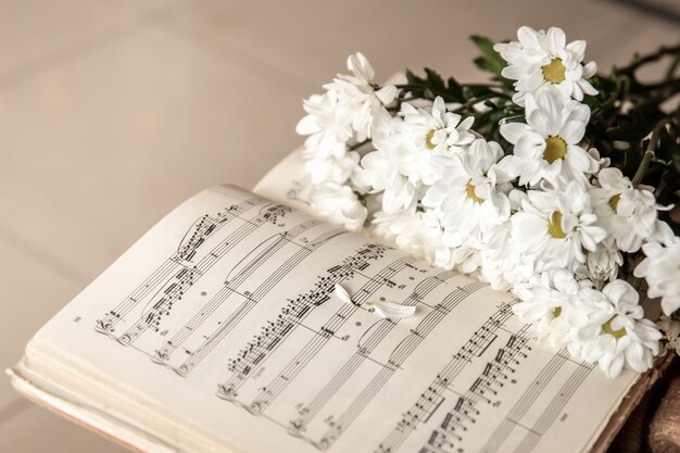 Primer plano de notas musicales y un ramo de flores