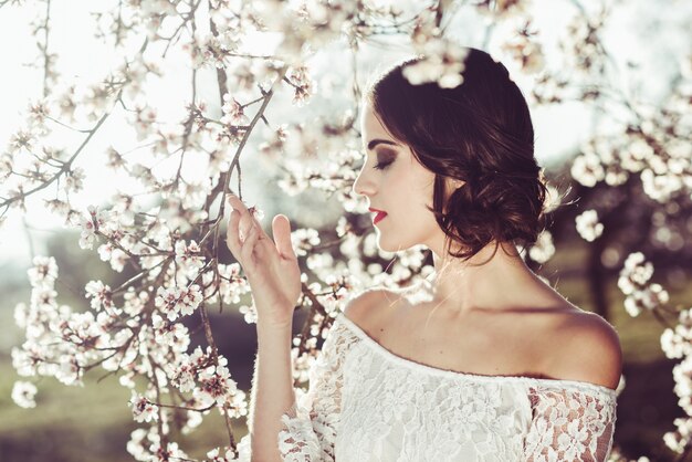 Primer plano de novia hermosa tocando una rama al aire libre