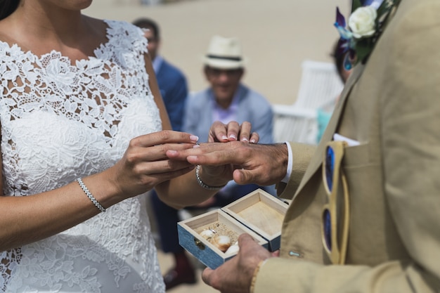 Foto gratuita primer plano de una novia poniendo un anillo de bodas en la mano del novio