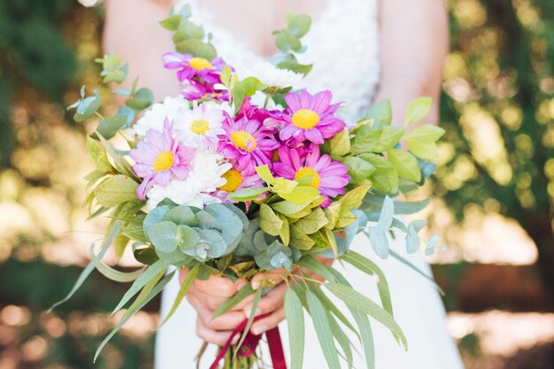 Primer plano de la novia con ramo de flores de colores