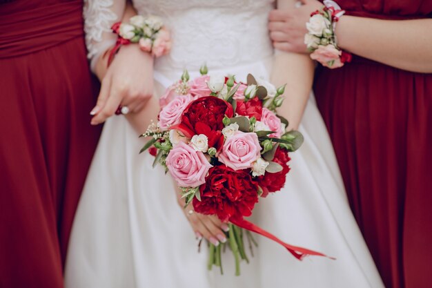 Primer plano de novia sujetando el ramo de boda con las damas de honor