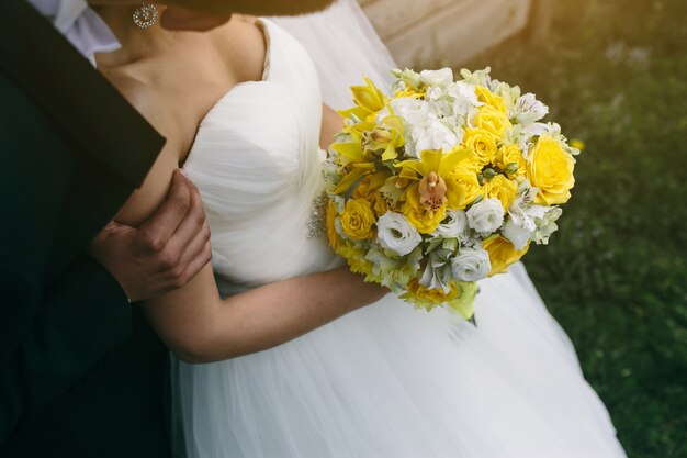 Primer plano de la novia sujetando un ramo de rosas