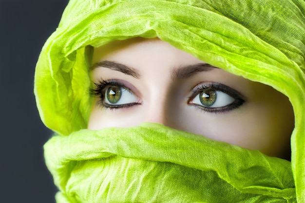Foto gratuita primer plano de los ojos de una mujer con un hijab verde bajo las luces
