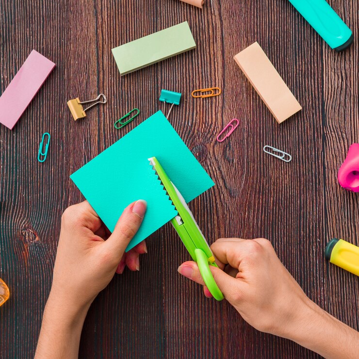 Foto gratuito primer plano de papel de corte de mano humana en escritorio de madera