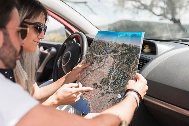 Primer plano de una pareja en coche mirando el mapa