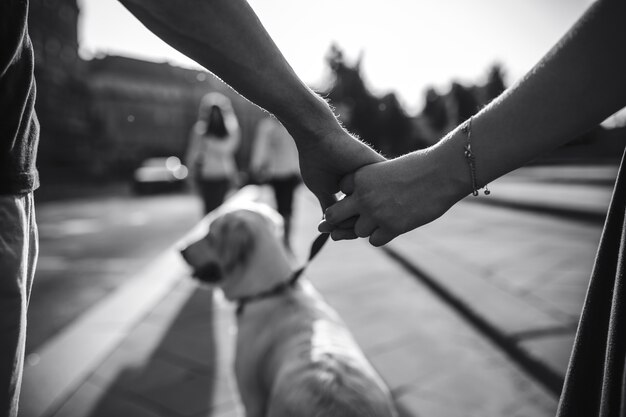 Primer plano de pareja cogiéndose de las manos en blanco y negro