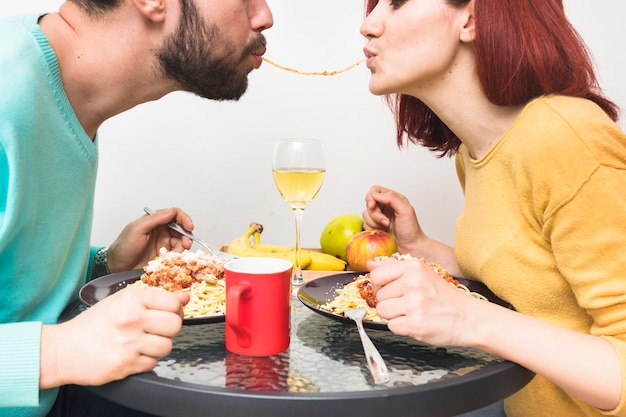 Foto gratuita primer plano de una pareja compartiendo fideos durante la cena