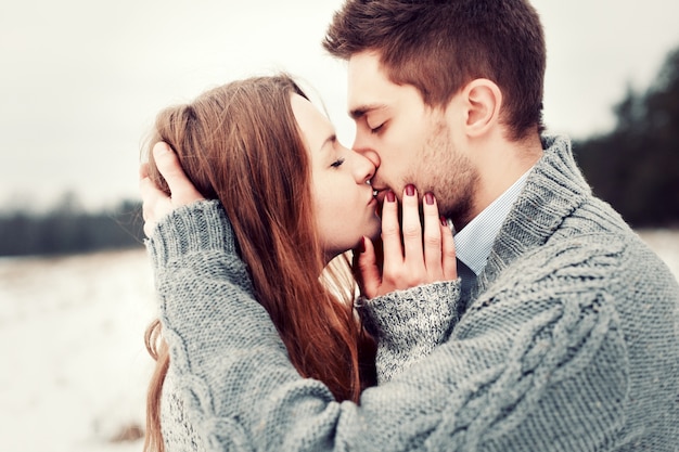 Primer plano de pareja enamorada posando mientras se besan