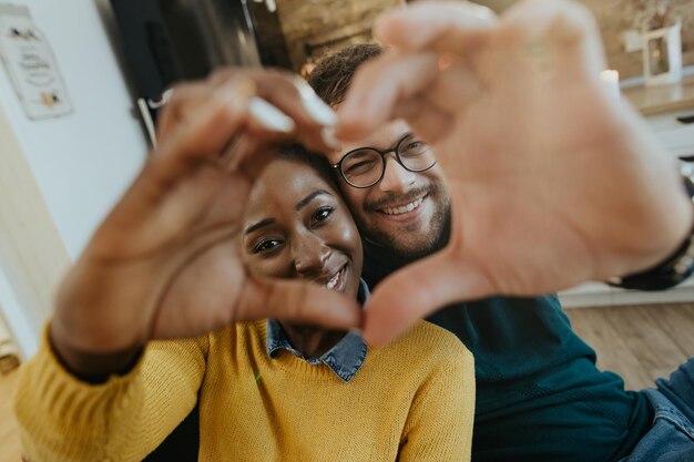 Primer plano de una pareja feliz haciendo forma de corazón con sus manos